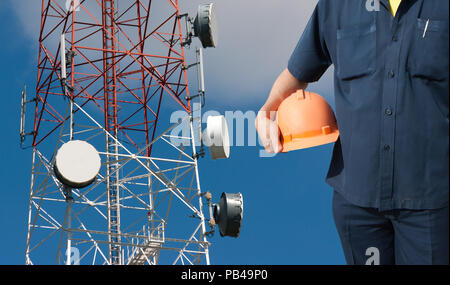 engineer holding orange helmet for workers security on Telecommunications tower background Stock Photo