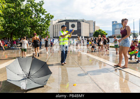 Sofia, Bulgaria - 8 July 2017: Children and adults participate in a fight with water guns and other water spray equipment in the center of Sofia. Stock Photo