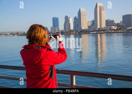Young woman takes photos using smart mobile phone Stock Photo