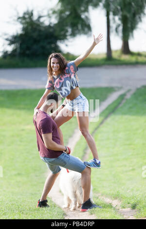 Lovely young couple having quality time with their dog in the park. Stock Photo