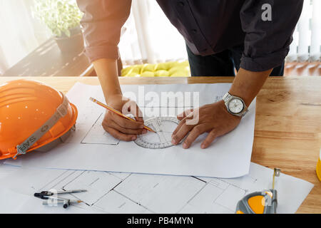 Architect or engineer using pencil and protractor working on blueprint, architectural concept Stock Photo