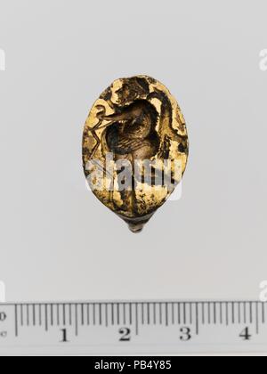 Gilt bronze ring. Culture: Greek. Dimensions: Length: 13/16 in. (2.1 cm). Date: early 4th century B.C..  Fat hunter carrying quadruped and bird. Museum: Metropolitan Museum of Art, New York, USA. Stock Photo
