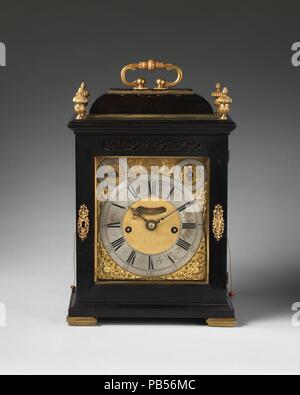 Table or bracket clock. Culture: British, London. Dimensions: Overall: 16 1/4 × 10 1/2 × 7 in. (41.3 × 26.7 × 17.8 cm). Maker: Clockmaker: Thomas Tompion (British, 1639-1713). Date: ca. 1696.  This portable clock has a repeating mechanism allowing it to strike on the quarter hour and hour, a valuable feature in darkness. Except for special commissions, the cases of Tompion table clocks tended to be rather sober. Where ebony was used, the clockmaker relied on the pleasing effect of the plain black surface to contrast with the gold and silver of the dial and applied hardware (the vase-shaped fin Stock Photo