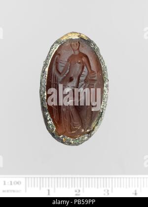 Glass oval set in a gilt bronze ring. Culture: Greek. Dimensions: Overall: 1 1/4 x 11/16 in. (3.2 x 1.8 cm). Date: 3rd-2nd century B.C..  Aphrodite holding her himation behind her body. Museum: Metropolitan Museum of Art, New York, USA. Stock Photo