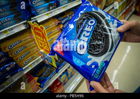 A hungry shopper chooses a package of classic Nabisco Oreo Cookies, from the myriad varieties available, from a supermarket shelf in New York on Tuesday, July 14, 2018.  (© Richard B. Levine) Stock Photo