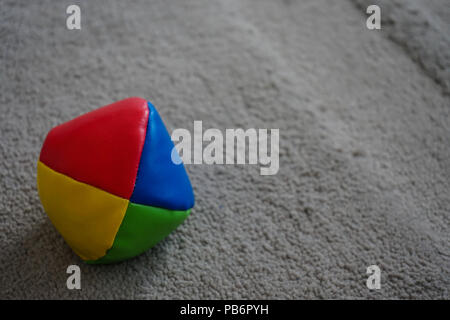 juggle ball on grey carpet red yellow blue green Stock Photo