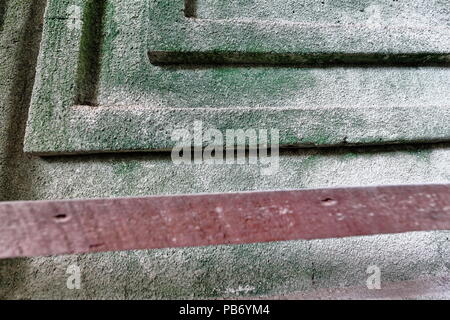 Detail of schematic decoration with geometrical angular motifs on the rough coral stone walls faded to a greenish hue of the Santa Monica Parish Churc Stock Photo