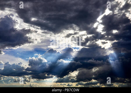 A cloudy sky with sun rays shining through the  clouds Stock Photo