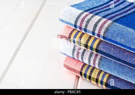 Stack of towels in cage on white wooden table. Studio Photo Stock Photo