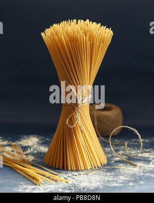 Bunch of uncooked Italian pasta spaghetti on a blue background Stock Photo