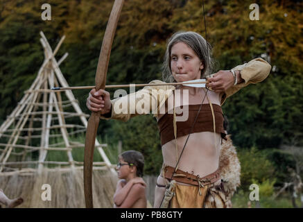 Albersdorf, Germany. 24th July, 2018. A woman practises archery with a self-made bow. Around 80 men, women and children met in Alberdorf in the district of Dithmarschen under the motto 'largest Stone Age meeting since the Stone Age'. Credit: Axel Heimken/dpa/Alamy Live News Stock Photo