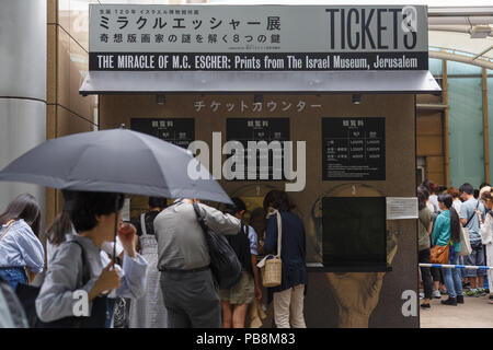 Tokyo, Japan. 27th July, 2018. Visitors buy tickets to enter to the Ueno Royal Museum to see ''The Miracle of M.C. Escher Prints from The Israel Museum, Jerusalem'' exhibition on July 27, 2018, Tokyo, Japan. The exhibition introduces a selection of 150 works (selected from The Israel Museum) of the Dutch graphic artist Maurits Cornelis Escher at Ueno Royal Museum until July 29. (Photo by Rodrigo Reyes Marin/AFLO) Credit: Aflo Co. Ltd./Alamy Live News Stock Photo