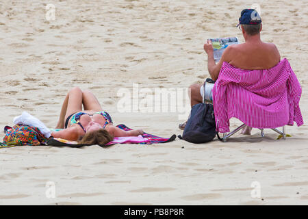 Bournemouth, Dorset, UK. 27th July 2018. UK weather: Sunseekers head to the seaside to soak up the sun at Bournemouth beaches on a warm humid day with some cloud cover. Credit: Carolyn Jenkins/Alamy Live News Stock Photo
