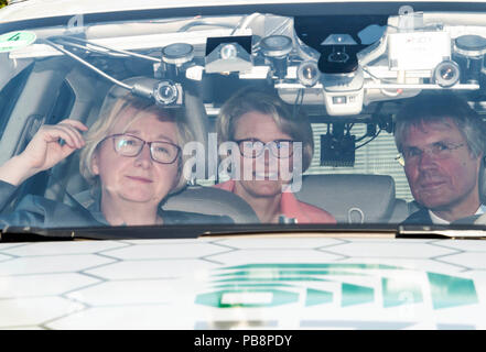 27 July 2018, Germany, Eggenstein-Leopoldshafen: Anja Karliczek (CDU, C), Federal Research Minister, sitting in an autonomously driving car during a visit at the Karlsruhe Institute of Technology (KIT). To her left is Theresia Bauer (Alliance 90/The Greens), Research Minister of Baden-Württemberg, and to her right is Holger Hanselka, President of KIT. Photo: Uli Deck/dpa Stock Photo