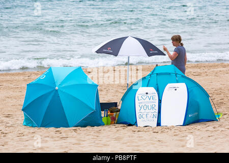 Bournemouth, Dorset, UK. 27th July 2018. UK weather: Sunseekers head to the seaside to soak up the sun at Bournemouth beaches on a warm humid day with some cloud cover. Love your ocean. Credit: Carolyn Jenkins/Alamy Live News