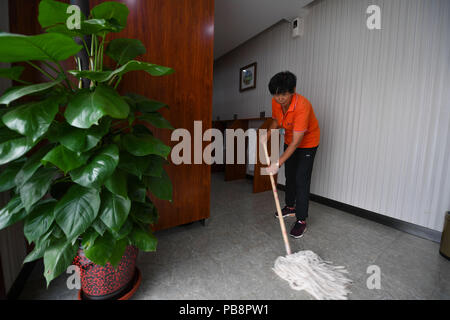 (180727) -- HOHHOT, July 27, 2018 (Xinhua) -- A cleaner works at an upgraded toilet in the Huimin District of Hohhot, capital of north China's Inner Mongolia Autonomous Region, July 27, 2018. In order to better serve people, toilets in the Huimin District of Hohhot have been upgraded to a combination of public toilets, bookstores, tea houses, convenience stores and self-service banks since 2017. A total of 31 upgraded toilets have been constructed and 99 more will be finished by the end of this year. (Xinhua/Peng Yuan) Stock Photo