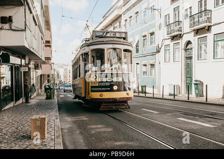 Portugal, Lisbon, June 01, 2018: A traditional yellow old-fashioned or retro style tram ride down the city street. Stock Photo