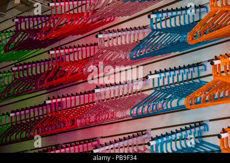 Plastic multicolour clothes hanger background. Orange, blue, red, pink and purple hangers on a shop for sale. No people. Stock Photo