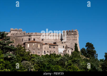 View of a Caetani medieval stone on top of a hill surrounded by wild nature with blue sky in the background. Sermoneta, Italy. No people. Stock Photo