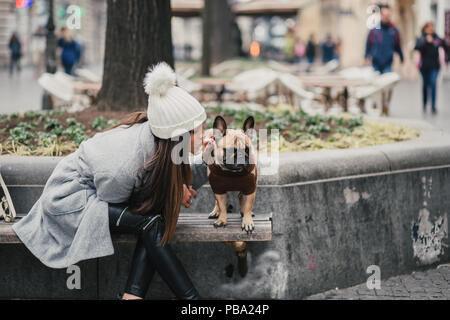 Beautiful brunette woman enjoying with her adorable French bulldog. Stock Photo