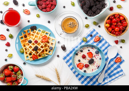 Photo of Viennese waffles, oatmeal, coffee, raspberries, strawberries, gooseberries Stock Photo
