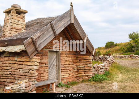 Old cottage built of limestone with thatched roof Stock Photo