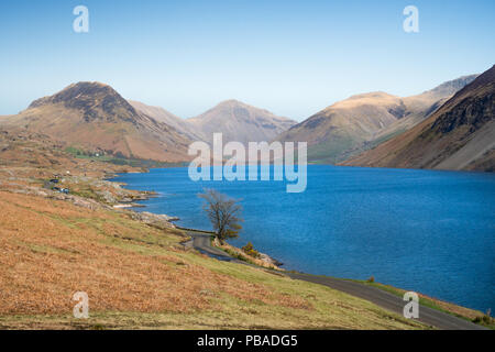 Street leading along a blue lake, with highlands in the background, at Wast Water, Cumbria, England Stock Photo