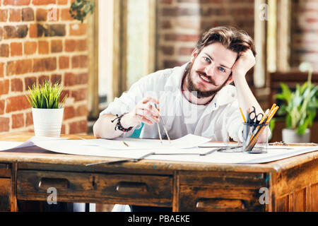 Bearded awesome male architect in white shirt with dividers and blueprint smiling in loft office Stock Photo