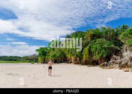 Man walking along the Coral Coast of Fiji at midday Stock Photo