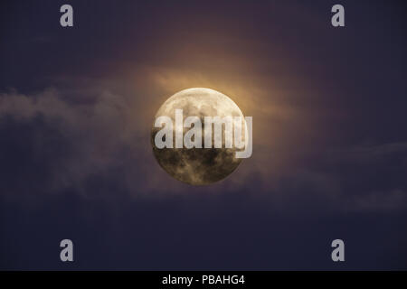 Bright full moon against dark clouds Stock Photo