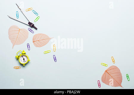 School supplies and orange leaves on a blue background. Back to school concept. Stock Photo