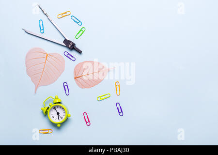 School supplies and orange leaves on a blue background. Back to school concept. Stock Photo