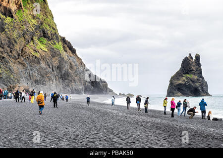 Myrdal, Iceland - June 14, 2018: Reynisfjara black sand beach from volcanic rocks, formation, seashore, coastline, many people, tourists walking, taki Stock Photo