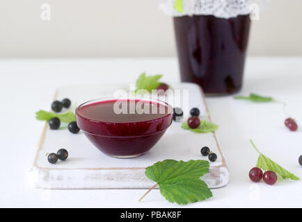 Jam or marmalade of black and red currant and currant berries on a light background. Selective focus. Stock Photo