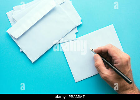 Hand writing address on blank white envelope, mock up image for communication and correspondence themes Stock Photo