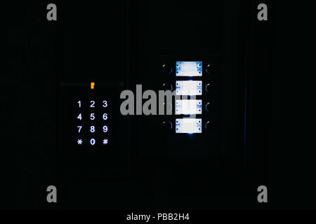 Close-up. The intercom at the entrance to the residential building in the night. Means of communication or notification of arrival and security of the entrance inside. Stock Photo