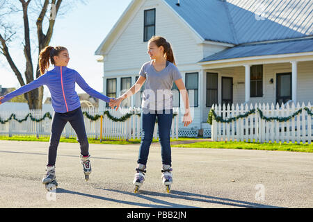 Teen girls group rolling skate in the street outdoor Stock Photo