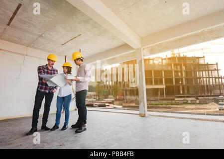 three construction engineers working together in construction site planning for the renovation Stock Photo