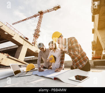 three construction engineers working together in construction site planning for the renovation Stock Photo