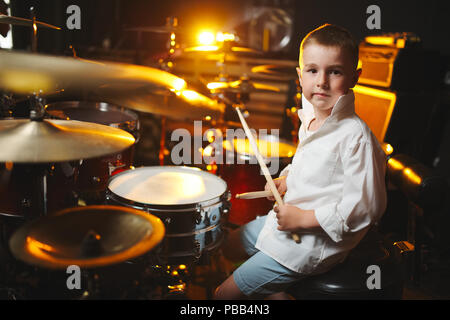 little boy plays drums in recording studio Stock Photo