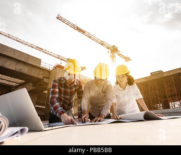 three construction engineers working together in construction site planning for the renovation Stock Photo