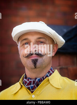 Portrait close up of isolated handsome man with waxed moustache & newsboy cap looking dapper in 1940s dress, Black Country Museum 1940's WWII event. Stock Photo