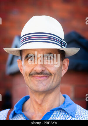 Close-up, front view portrait of smiling caucasian gentleman in straw panama hat outdoors at the Black Country Living Museum 1940's event, July 2018. Stock Photo