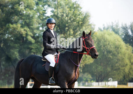 Young Chinese man riding horse Stock Photo