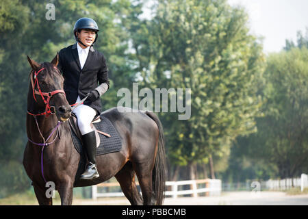 Young Chinese man riding horse Stock Photo