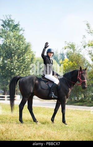 Young Chinese man riding horse Stock Photo