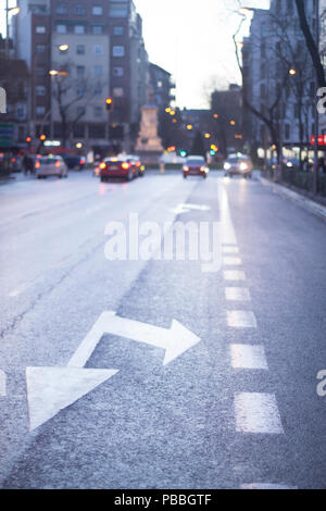 City street in Madrid Spain road traffic control markings arrows indicating lanes straight on and righ turn. Stock Photo