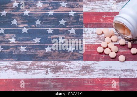 Bottle of pills spill on American flag with room for text Stock Photo