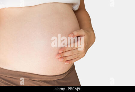 Pregnant woman holding her hand on belly Stock Photo