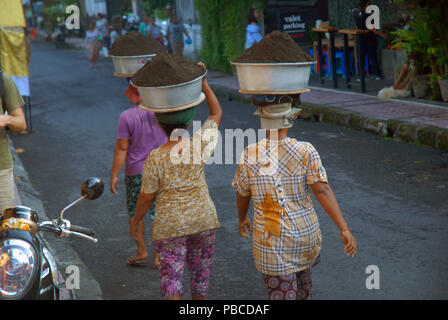 Women carrying bowls of dirt on their heads, Ubud, Gianyar, Bali, Indonesia Stock Photo